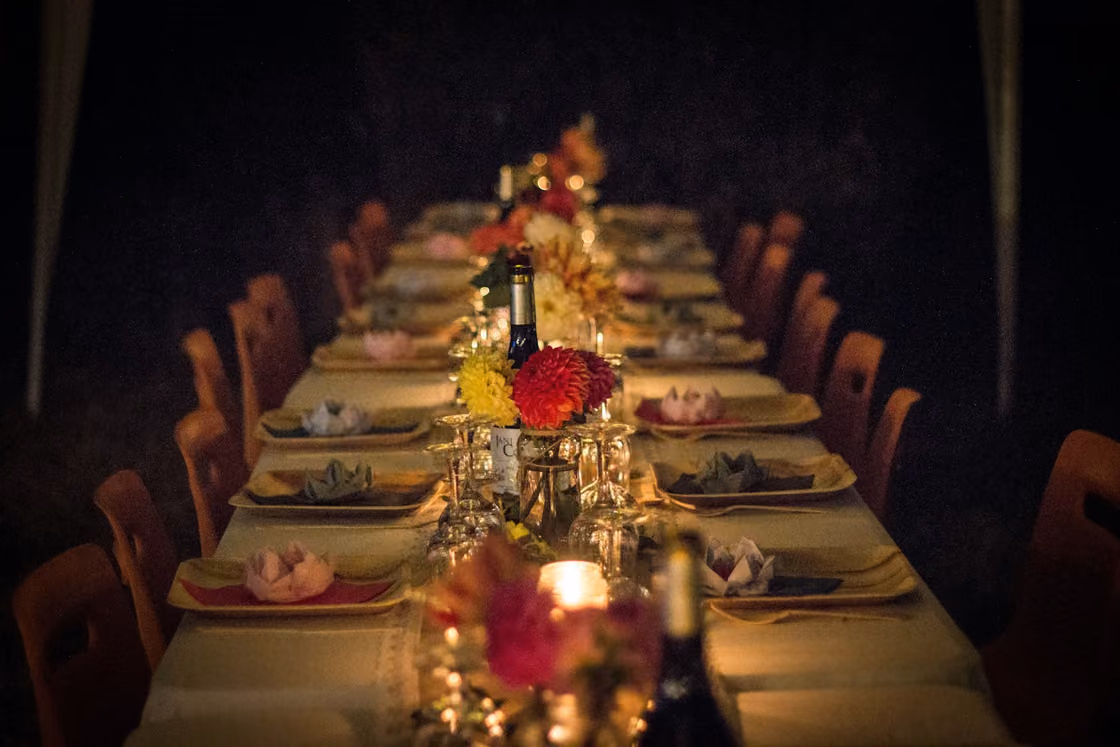 Lange gedeckte Tafel mit Kerzen und Blumen