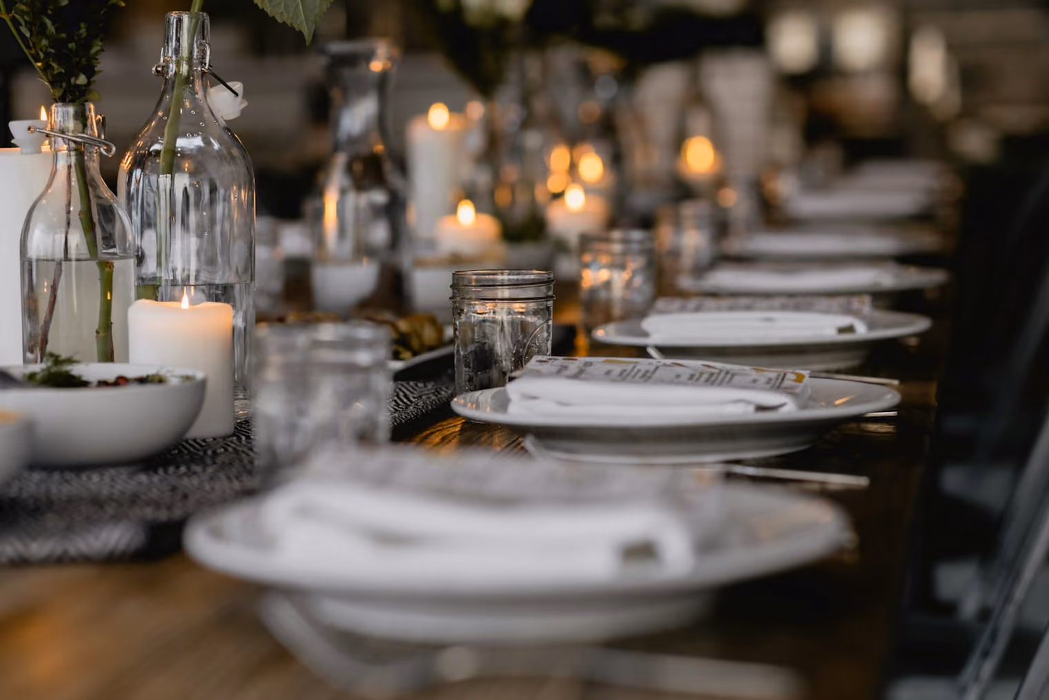 Gedeckter Tisch mit Kerzen und weißen Tellern