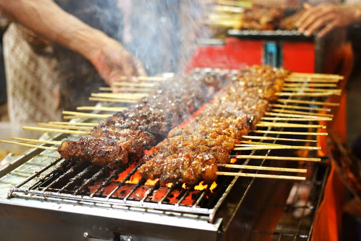Grillspieße über glühender Holzkohle