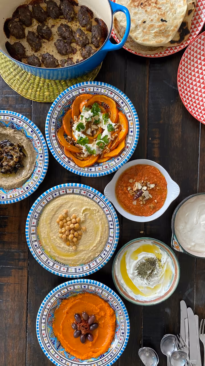 Hummus, Kürbis und weitere Mezze in bunten Schalen