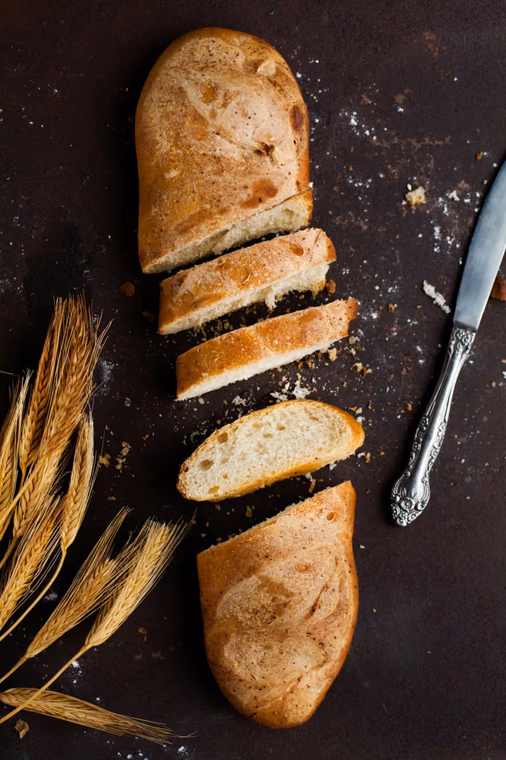Angeschnittenes Sauerteigbrot neben einem Brotmesser